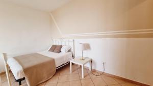 トロペアにあるBov'Apartmentの白いベッドルーム(ベッド1台、テーブル付)