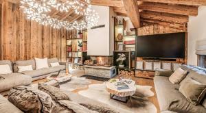 a living room with a couch and a tv at Résidence Casa San Bernardo - Chalets pour 18 Personnes 851 in Tignes