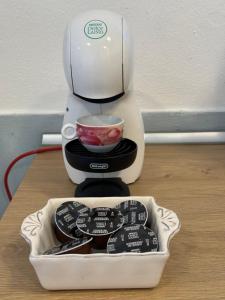 una macchinetta del caffè seduta su un tavolo con una ciotola di Atelier La Maison a Querceta