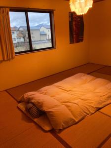 1 cama no hecha en una habitación con ventana en Minshuku Miyoshi - Vacation STAY 14454v en Echizen