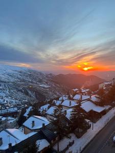 a city covered in snow with the sunset in the background at ALCAZABA CON VISTAS INCREIBLES in Sierra Nevada