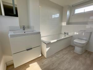 a bathroom with a sink and a toilet and a bath tub at Buttercup Victorian House for 6 in St. Leonards