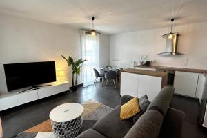 een woonkamer met een bank en een tafel bij 040- La Movida - Gare Sud de France * 2chambres, Piscine, Clim, 2Parking in Lattes
