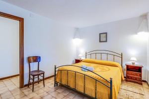 - une chambre avec un lit, une chaise et un miroir dans l'établissement Villa Serra, à Cuglieri