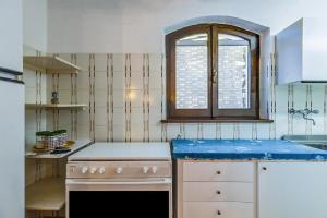 une cuisine avec une cuisinière et une fenêtre dans l'établissement Villa Serra, à Cuglieri