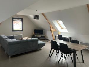 a living room with a couch and a table and chairs at Ducey Appart'Hôtel - Les Rivières in Ducey