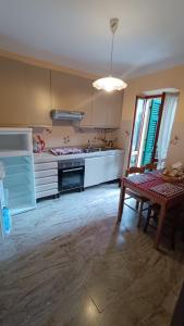 a kitchen with a table and a stove and a sink at Sopra_lavia Stazione_La Spezia_Cinque Terre in La Spezia