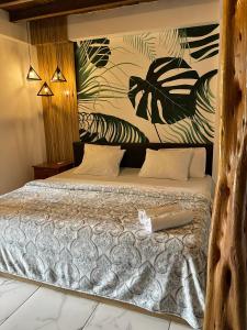 - une chambre avec un lit orné d'une fresque murale représentant la plante dans l'établissement Casa Peregrina, à Ayampe
