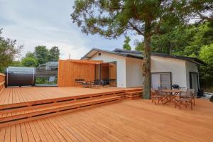 ein Haus mit einer großen Terrasse mit einem Baum in der Unterkunft VOYAN RESORT Izu MADOKA - Vacation STAY 14897v in Ito
