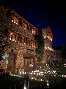 a building with lights in front of it at night at Casa Rural Era de Ferro in Erill la Vall