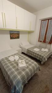 two beds in a room with white cabinets at Sopra_lavia Stazione_La Spezia_Cinque Terre in La Spezia