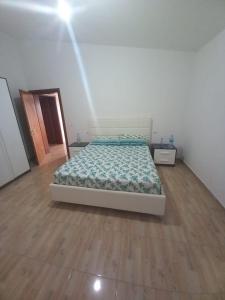 um quarto com uma cama e piso em madeira em Vila Toscana em Baks-Rrjoll