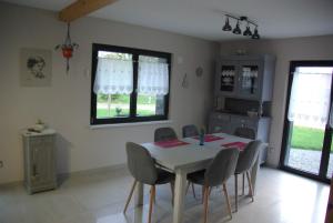 a dining room with a table and chairs and windows at Gîte Les Hérissons in Guevenatten