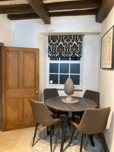 a dining room with a table and chairs and a window at Cromwell Cottage in Fakenham