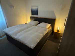een slaapkamer met een groot bed met witte lakens en kussens bij Casa Manderscheid in Manderscheid