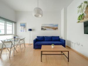 un soggiorno con divano blu e tavolo di Plz de la Merced Apartamentos Solera by Life in Malaga a Málaga