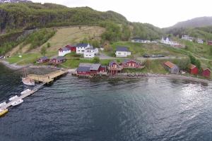 un gruppo di case su una collina vicino all'acqua di Elvegård Fjordcamp a Grov