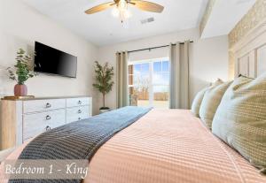 Un dormitorio con una cama con televisor y una ventana. en Luxury Lakefront: 9BR/8.5BA, Views, Peak Comfort, en Branson