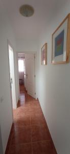 a hallway with white walls and a tile floor at GAVIOTA RELAX in Tarajalejo