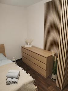 a bedroom with a bed and a dresser with towels at Klatovy Apartment in Klatovy