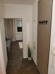 een hal met een kamer met witte muren en houten vloeren bij Klatovy Apartment in Klatovy