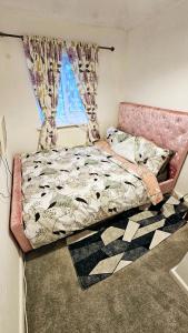 Mo's home في تيلبوري: سرير بإطار وردي في غرفة النوم