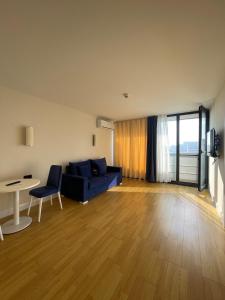 uma sala de estar com um sofá azul e uma mesa em Orbi city Panorama towers em Batumi