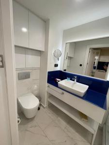 W łazience znajduje się umywalka, toaleta i lustro. w obiekcie Orbi city Panorama towers w mieście Batumi