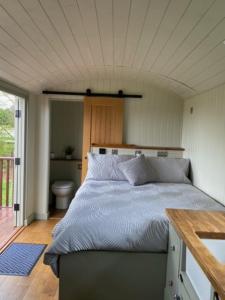 ein Schlafzimmer mit einem großen Bett in einem Haus in der Unterkunft Woodpecker Shepherds Hut in Boston
