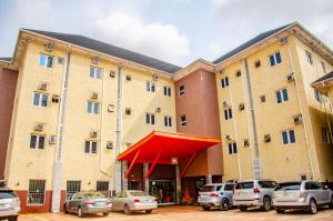 ein großes Gebäude mit davor geparkt in der Unterkunft Aify Queenest Hotel and Suites in Owerri