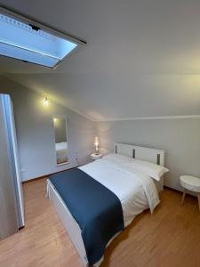 una camera con un grande letto bianco e un lucernario di RESIDENCE VIOLA a Foggia