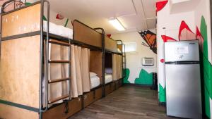 a dorm room with bunk beds and a refrigerator at RAD Hostel in Colorado Springs