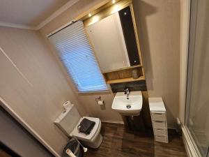 La petite salle de bains est pourvue d'un lavabo et de toilettes. dans l'établissement Rockley Park, The Poplars, à Lytchett Minster