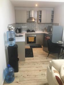 a kitchen with a stove top oven next to a living room at maasaifari elite in Nairobi