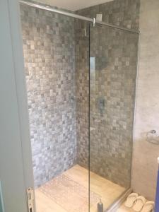 a shower with a glass door in a bathroom at maasaifari elite in Nairobi