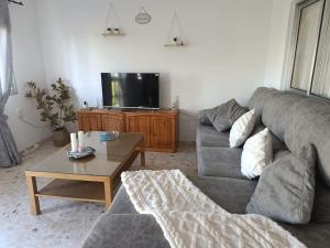 a living room with a couch and a tv at Bonita casa en Sevilla in San Pablo