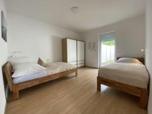 a bedroom with two beds and a window at Neu Apartment in Schloß nähe,Parkplatz, Netflix in Sögel +13 photos