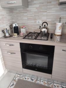 una cucina con piano cottura e bollitore per il tè di MagicaHome ad Alghero Altre 27 foto
