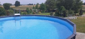 a large blue swimming pool in a yard at Agroturystyka "na łąkach" in Garczegorze
