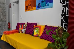 a yellow couch with colorful pillows in a room at Sevilla Urban Flat in Seville