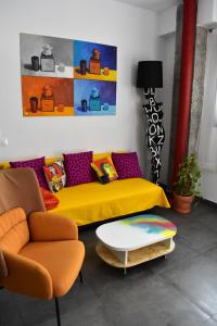 uma sala de estar com um sofá amarelo e uma mesa em Sevilla Urban Flat em Sevilha