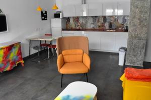 uma cozinha com uma cadeira laranja e uma mesa em Sevilla Urban Flat em Sevilha