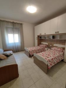 una grande camera con due letti e un divano di MagicaHome ad Alghero