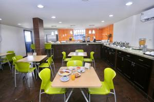 a dining room with tables and green chairs at Metro Hotel Panama in Panama City