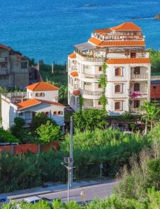 a large white building with an orange roof next to the ocean at Hotel plage d'or in Jijel
