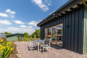 a patio with a table and chairs next to a building at Mount Hillary Holiday Pods in Cork