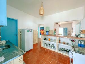 a kitchen with a refrigerator and a tile floor at Casa Pé Na Areia RN in Touros