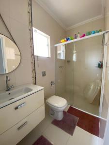 een badkamer met een toilet, een wastafel en een douche bij CURTA! | Charmoso sobrado 7min da Expoville in Joinville