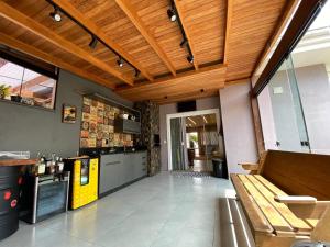 een grote keuken met houten plafonds en een houten bank bij CURTA! | Charmoso sobrado 7min da Expoville in Joinville