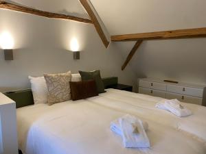 a bedroom with a large white bed with towels on it at Hotel De Hoogmolen in Oudsbergen 